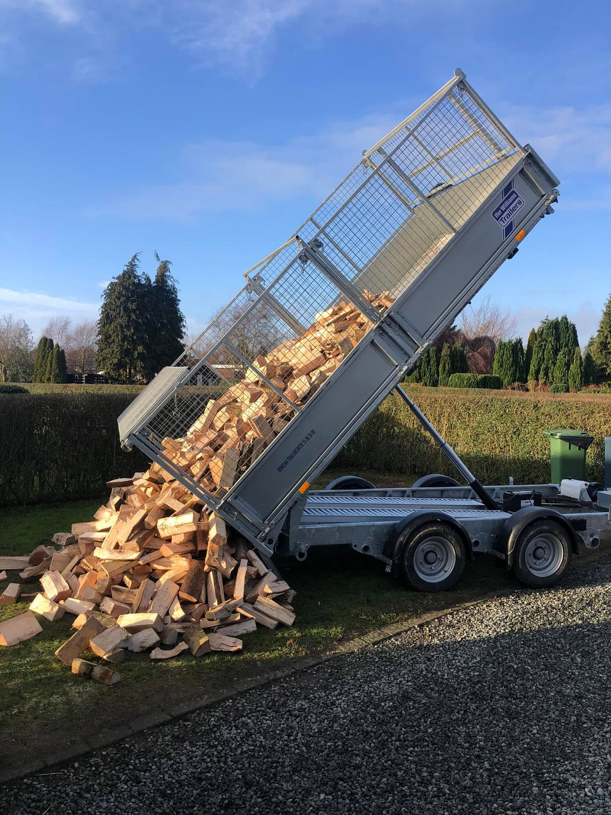 Levering van gekloofd brandhout met een kipper-aanhanger